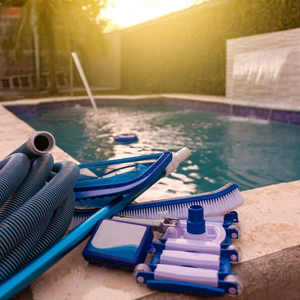 Pool cleaning and maintenance kit, Cleaning and maintenance tools on the edge of the pool. vacuum cleaner, ph test, skimmer and pool sweeper